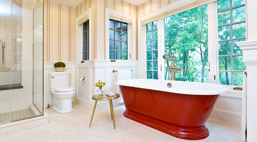 Gant Bathroom With Red Freestanding Tub, Shower, and Large Windows Overlooking Nature